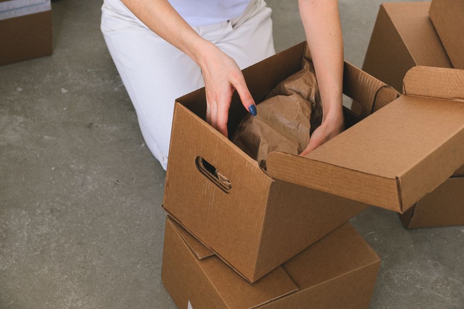 Local movers carefully packing cardboard boxes